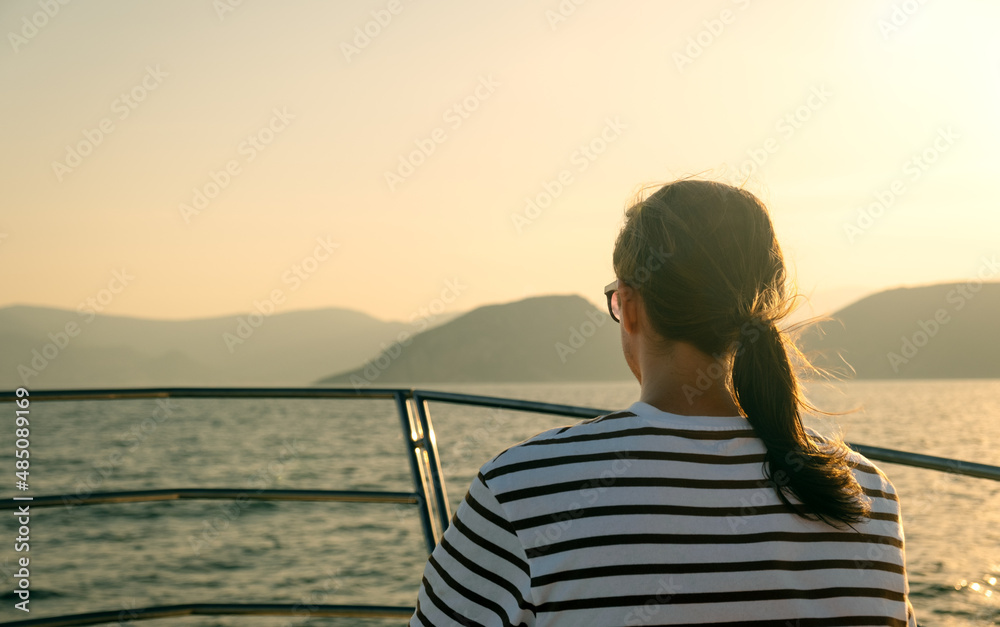 Young man sailing on luxury yacht at sunset. Holidays on the yacht
