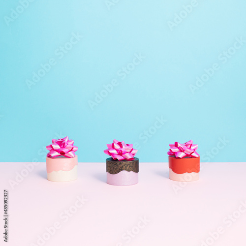 Three gift boxes with a bow on pastel blue and white background. Fashion, love or gift concept.