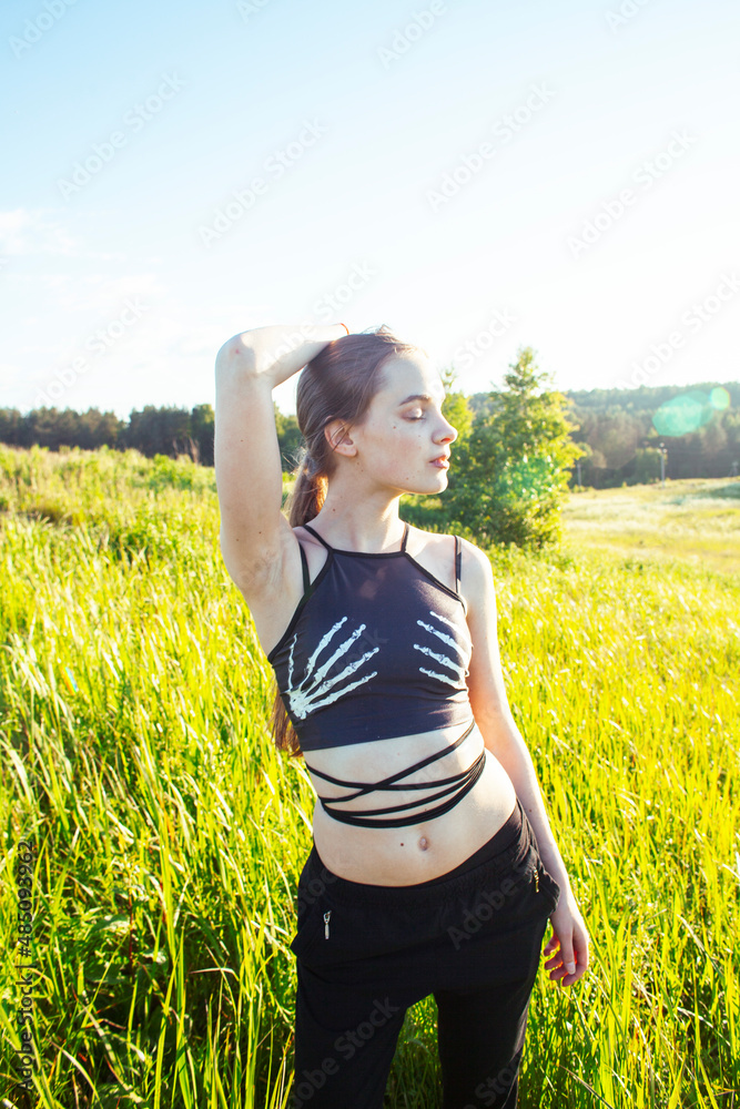 young pretty blond caucasian girl resting in green field at summer, lifestyle people concept