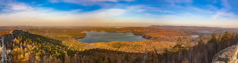 Panoramic view from the mountain to the lakes, forest against the blue sky in autumn