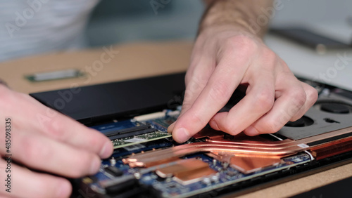 Unrecognizable engineer pulls out the RAM. Electronic renovation, business, occupation concept