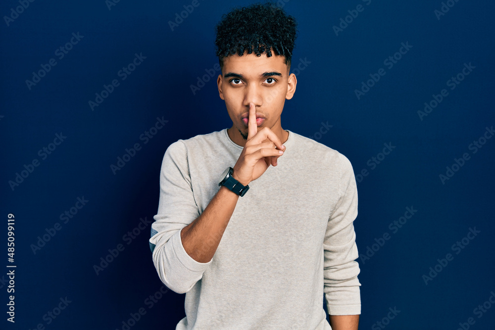 Young african american man wearing casual clothes asking to be quiet with finger on lips. silence and secret concept.