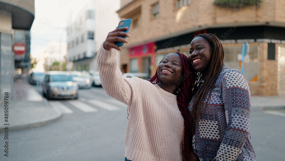 Two african american friends smiling confident making selfie by the smartphone at street
