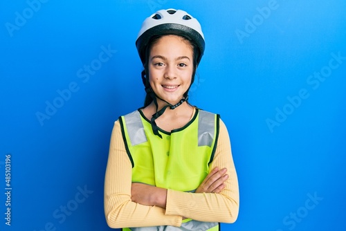 Beautiful brunette little girl wearing bike helmet and reflective vest happy face smiling with crossed arms looking at the camera. positive person.