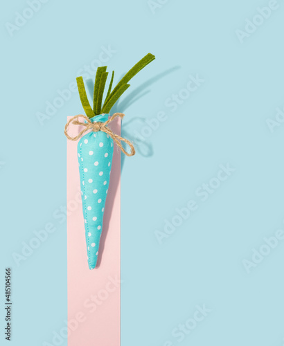 Light blue ornament carrot on a pastel background. Happy Easter minimal flat lay.