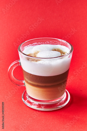  One cup of cappuccino coffee over red background