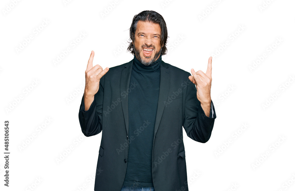Fototapeta premium Middle age handsome man wearing business clothes shouting with crazy expression doing rock symbol with hands up. music star. heavy concept.