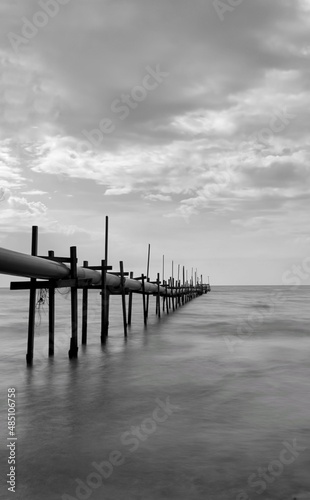 pipelines strectching to the sea in black and white