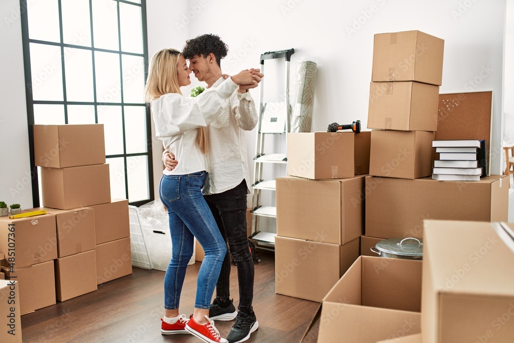 Young beautiful couple smiling happy dancing at new home Young beautiful couple smiling happy dancing at new home