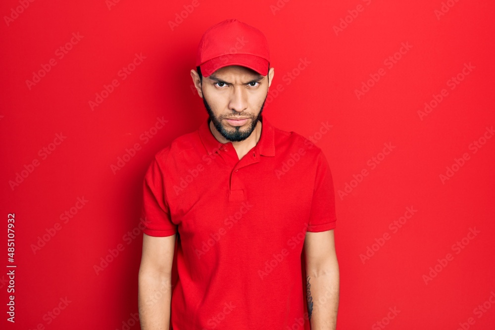 Hispanic man with beard wearing delivery uniform and cap skeptic and nervous, frowning upset because of problem. negative person. Hispanic man with beard wearing delivery uniform and cap skeptic and nervous, frowning upset because of problem. negative person.