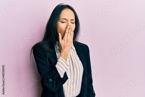 Young hispanic girl wearing business clothes bored yawning tired covering mouth with hand. restless and sleepiness.