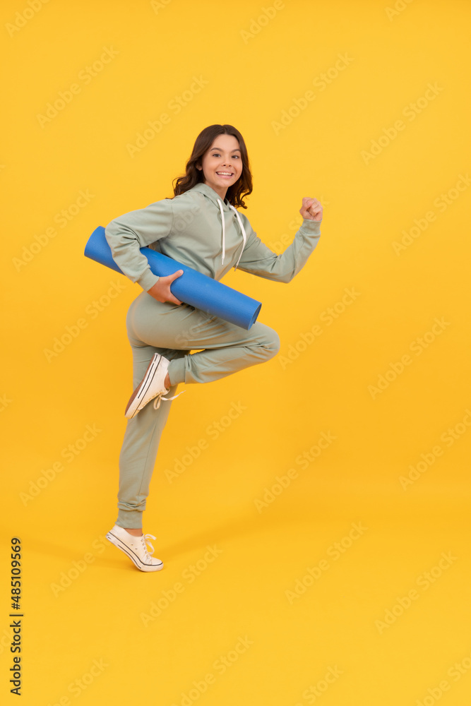 happy child in sportswear running with fitness mat. fit your body.