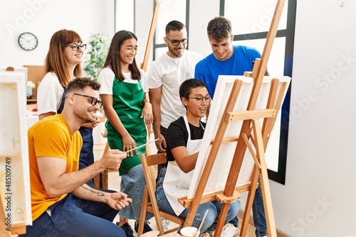 Group of people smiling happy and looking draw of partner at art studio.