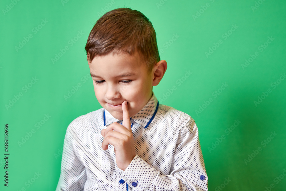 Cute boy holds his finger to his mouth, thinking about his actions. Cute boy holds his finger to his mouth, thinking about his actions.