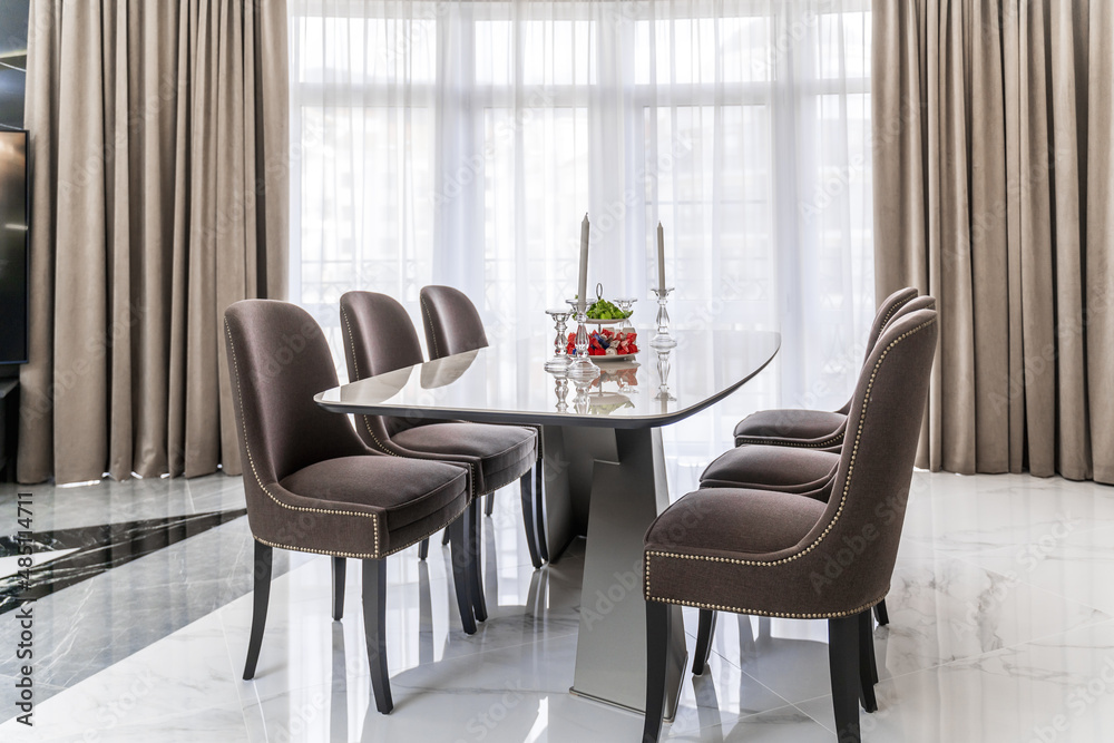 Oval light modern table and chairs with dark upholstery. Oval light modern table and chairs with dark upholstery.