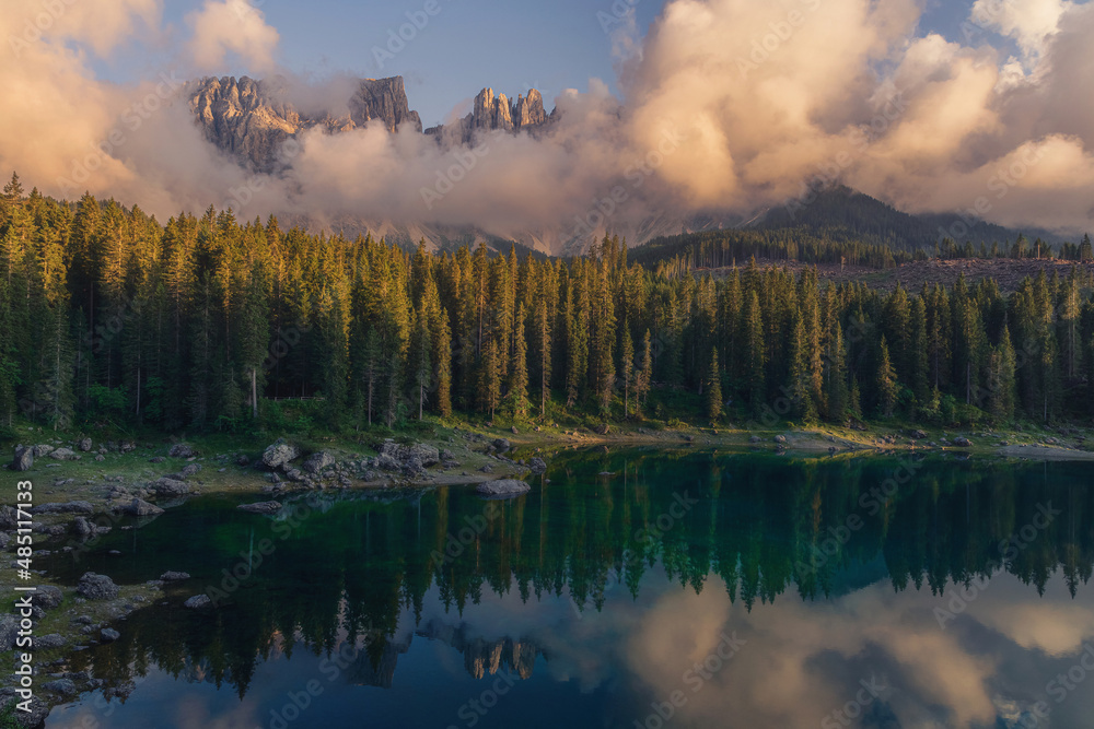 Dramatic sunset landscape of alpine Carezza lake or Lago di Carezza in Dolomites, South Tyrol, Alto Adige, Italy