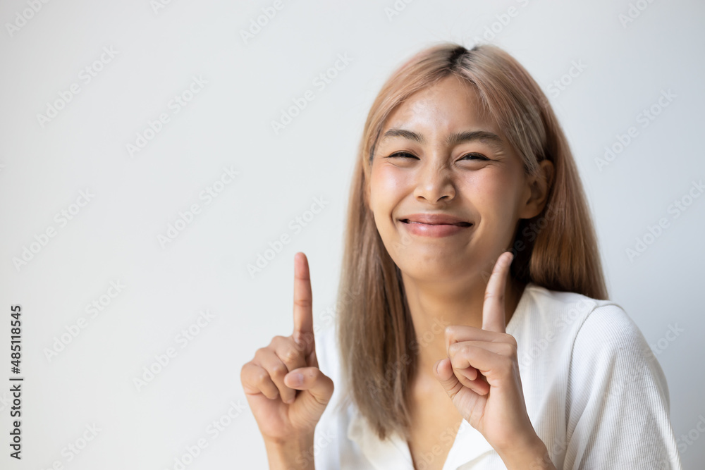 Excited southeast asian young adult woman with colored hair pointing up one finger of both hands Excited southeast asian young adult woman with colored hair pointing up one finger of both hands