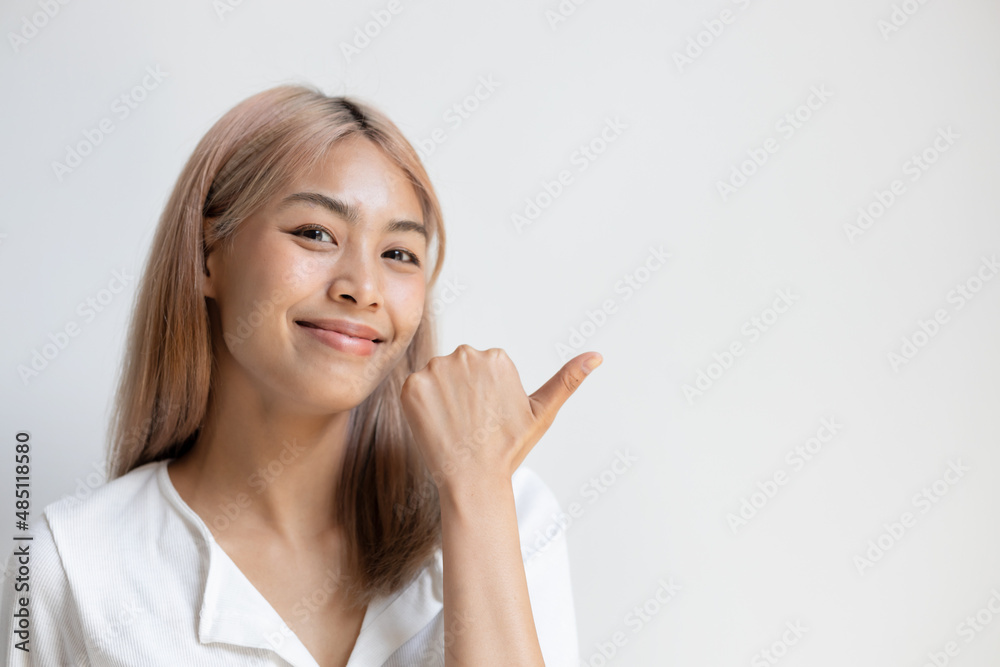 Happy smiling asian woman with colored hair pointing accepting, good, yes, ok thumb up gesture Happy smiling asian woman with colored hair pointing accepting, good, yes, ok thumb up gesture