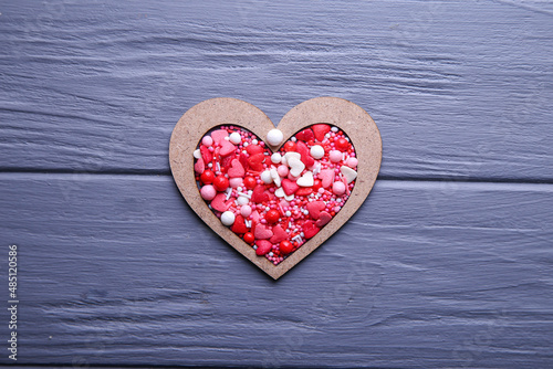 Heart of candy in wooden form on a grey background