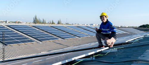 Specialist technician professional engineer with laptop and tablet maintenance checking installing solar roof panel on the factory rooftop under sunlight. Engineers holding tablet check solar roof. © whyframeshot