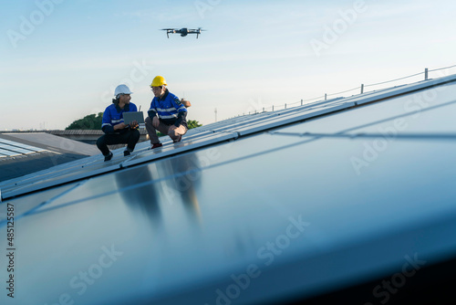 Murais de parede Specialist technician professional engineercontrol drone checking top view of installing solar roof panel on the factory rooftop under sunlight