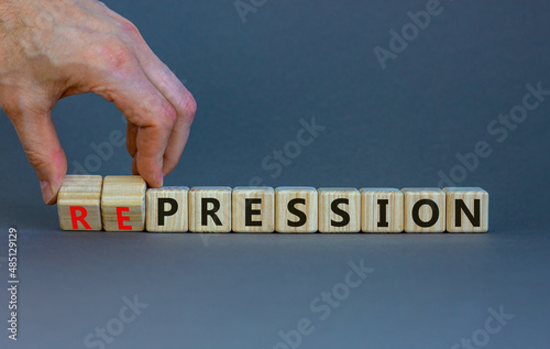 Pression to repression symbol. Businessman turns wooden cubes, changes the word pression to repression. Beautiful grey background. Business, pression to repression concept. Copy space. photo