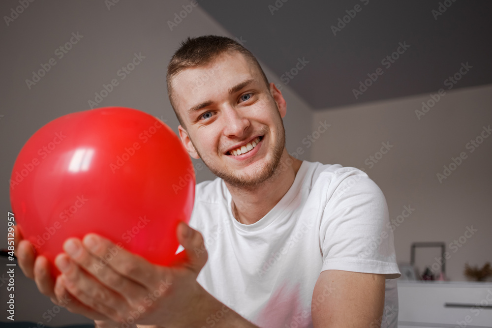 The guy holds a balloon in the form of a heart, for Valentine's Day The guy holds a balloon in the form of a heart, for Valentine's Day