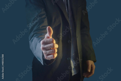 Thumbs up! A man in a suit shows a great sign. A sign of success and good luck. A sign of a job well done. photo