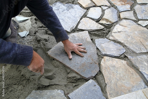 Cuadro en lienzo Worker using a trowel  wile build side walk