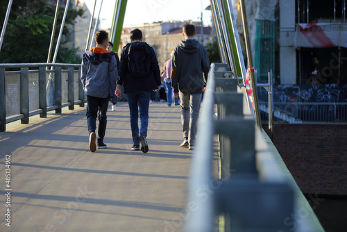Mężczyźni idą przez most we Wrocławiu.