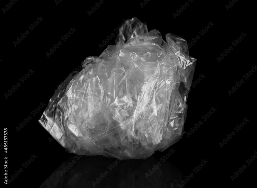 Crumpled transparent plastic bag on black  