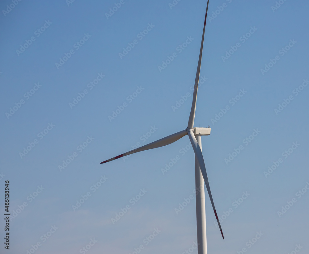 wind mill or also wind-turbine on wind farm in rotation to generate electricity energy on outdoor with sun and blue sky, conservation and sustainable energy concept wind mill or also wind-turbine on wind farm in rotation to generate electricity energy on outdoor with sun and blue sky, conservation and sustainable energy concept