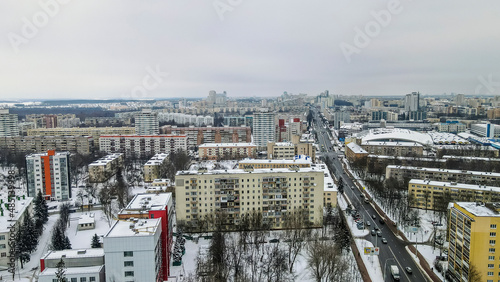 Aerial view of houses and road in the large city. Winter landscape. Residential areas in central of Minsk in the snow.