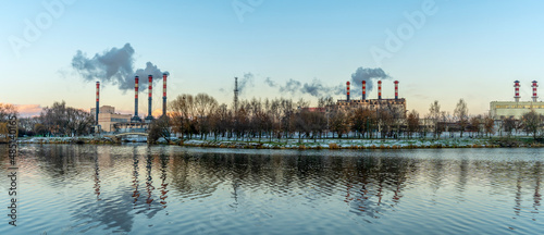 Smoking chimneys of a thermal power plant against a winter cloudy sky. Ecological problems concept. Space for text. © kalyanby