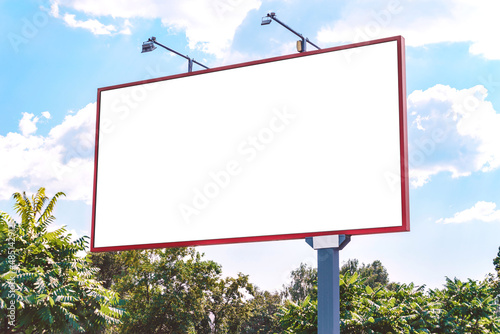Billboard mockup. against the backdrop of nature trees and blue sky with clouds.