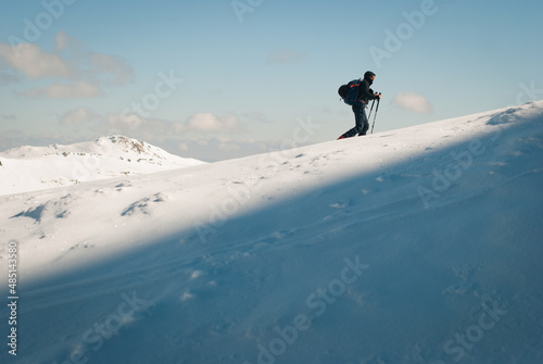 Man skitouring in the mountains. Healthy activity on snow. Good weather for winter sport and recreation. 