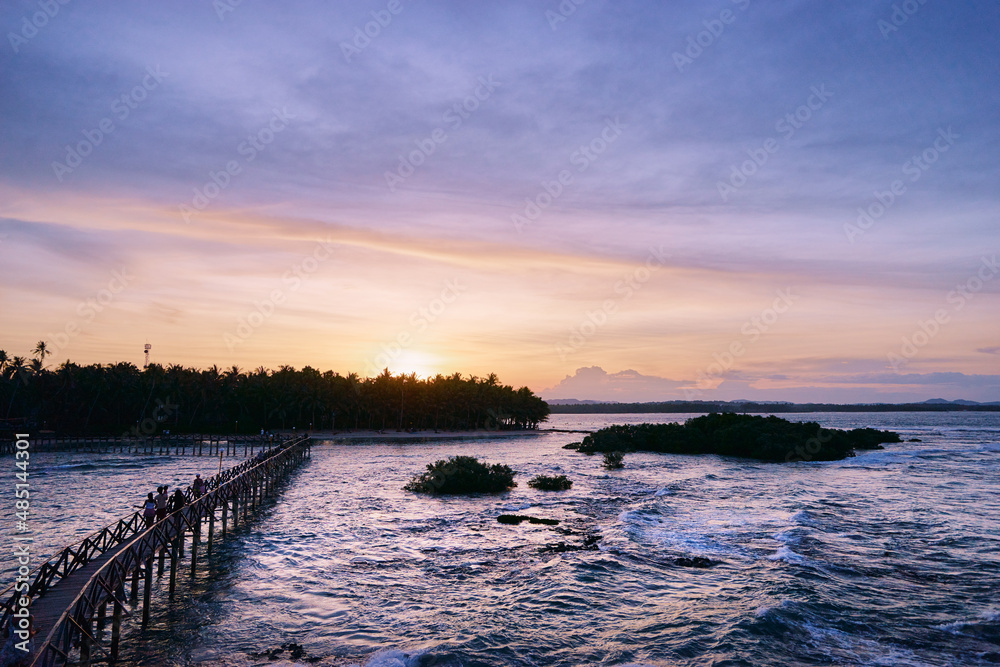 Obraz premium Beautiful landscape. Sunset on the seashore. Wooden bridge on Cloud 9 beach, Siargao Island Philippines.