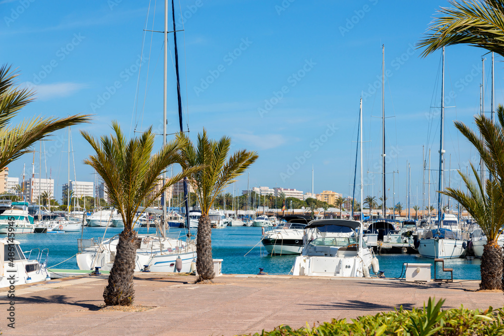 A beautiful marina with luxury yachts and motorboats in the tourist seaside town in Spain