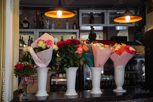 Bouquets with red and white roses in vases on the counter for the holiday.