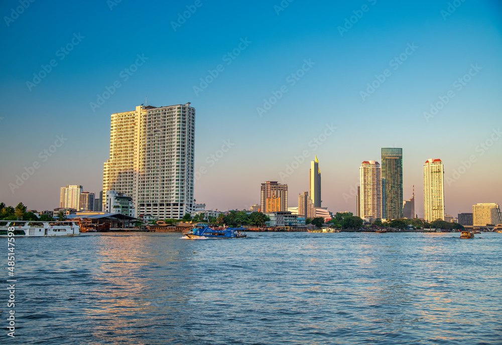 Bangkok, Thailand - January 5, 2020: Chao Phraya River and city skyscrapers from Asiatique Waterfront at sunset,.
