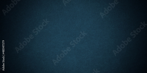 Dark blue background texture with black vignette in old vintage grunge textured border design, dark elegant teal color wall with light spotlight center 