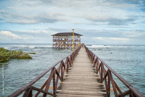 Beautiful landscape. Day on seashore. Wooden bridge on Cloud 9 beach, Siargao Island Philippines. photo