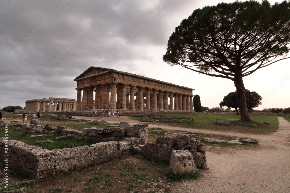 Tempio greco con rovine , un albero e cielo nuvoloso
