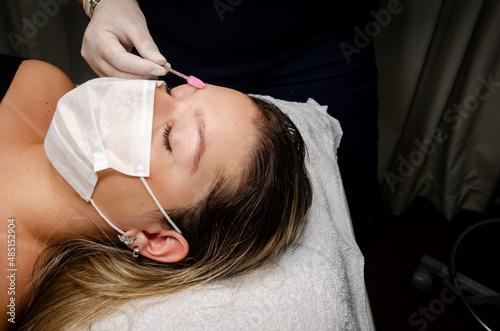 Young woman taking care of her eyebrows photo