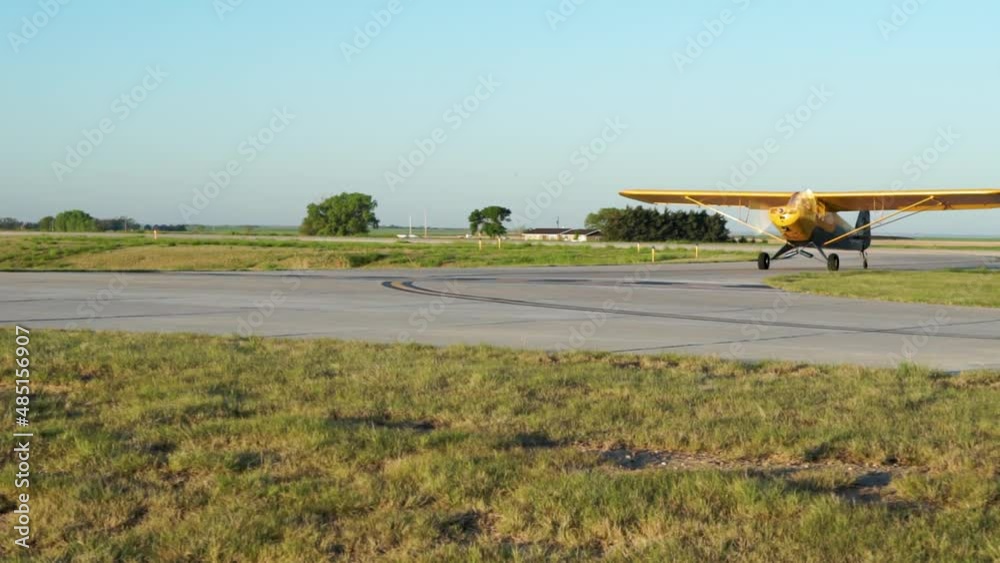 Small high wing airplane taxis off runway at rural airport Small high wing airplane taxis off runway at rural airport