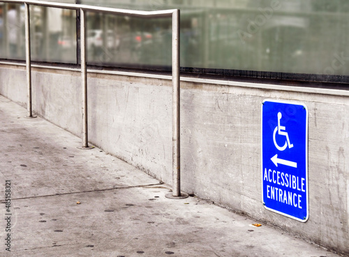 Sign showing the way to a ramp for an accessible entrance to a shop. No people.