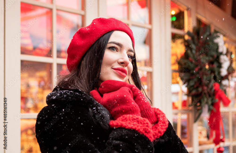 beautiful girl in a red beret and mittens in winter on New Year's street beautiful girl in a red beret and mittens in winter on New Year's street