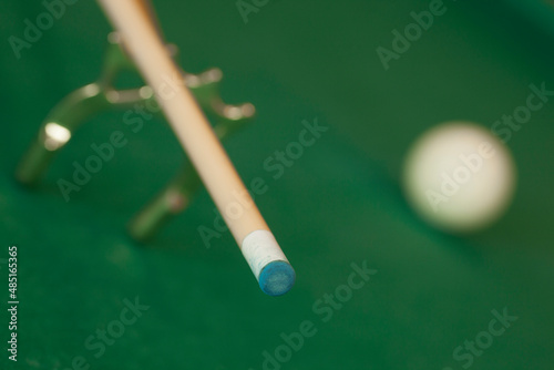 cue tip detail placed on special support and arranged on a pool table