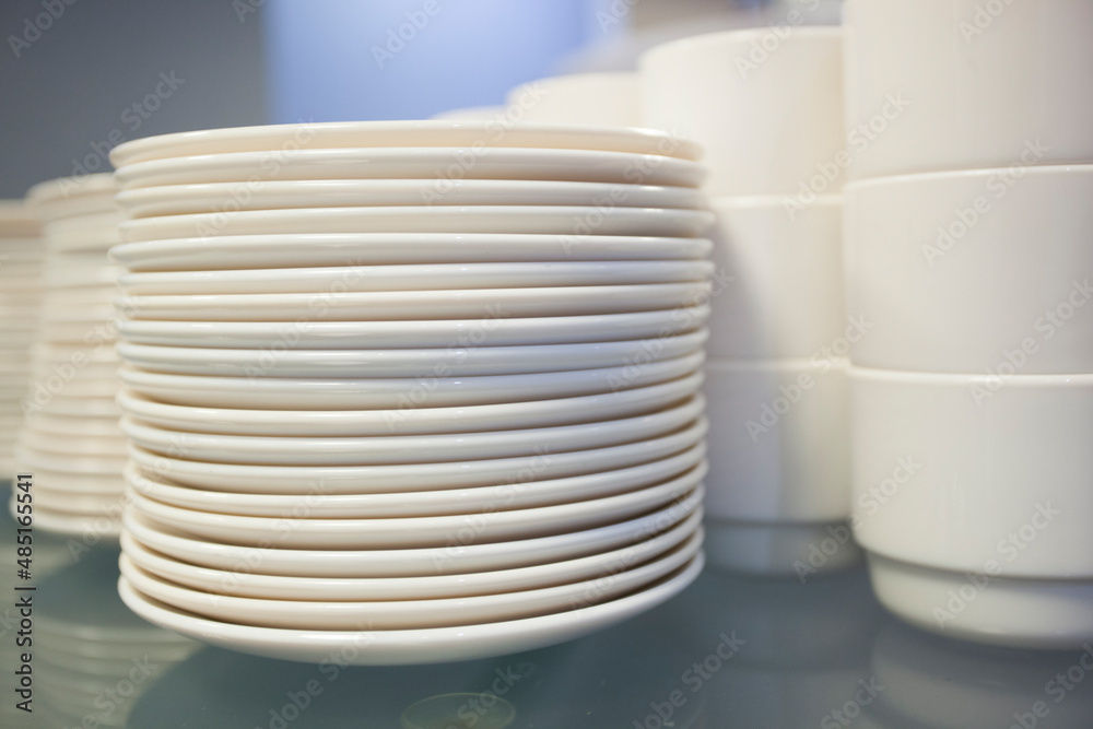 detail of plates and white cups of coffee arranged on top of each other on a table detail of plates and white cups of coffee arranged on top of each other on a table
