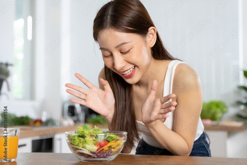 Smiled happy woman eating a bowl of salad as breakfast for good health.